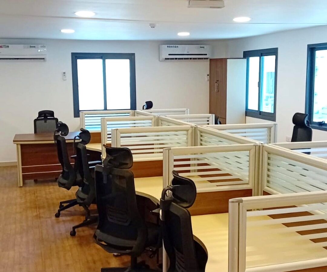 Fitted open-plan office inside a modular building, with workstations and chairs