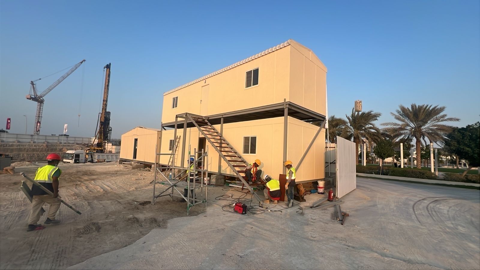 Two-storey modular building with an external steel staircase being installed on a construction site